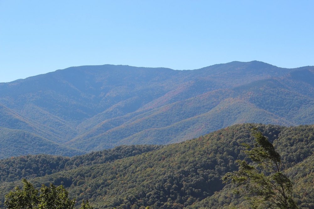 Mount Mitchell and Mount Craig rising above ridges of early fall color under a clear blue sky